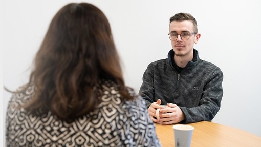 Students chatting at a table with a coffee